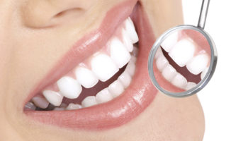 Healthy woman teeth and a dentist mouth mirror